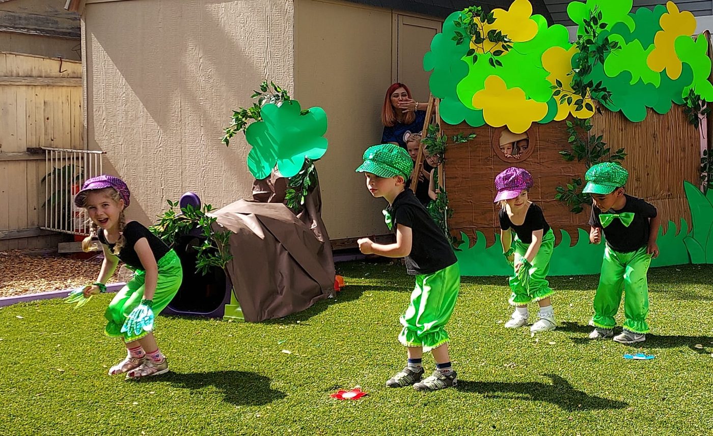 Children dancing together in costume during a music activity