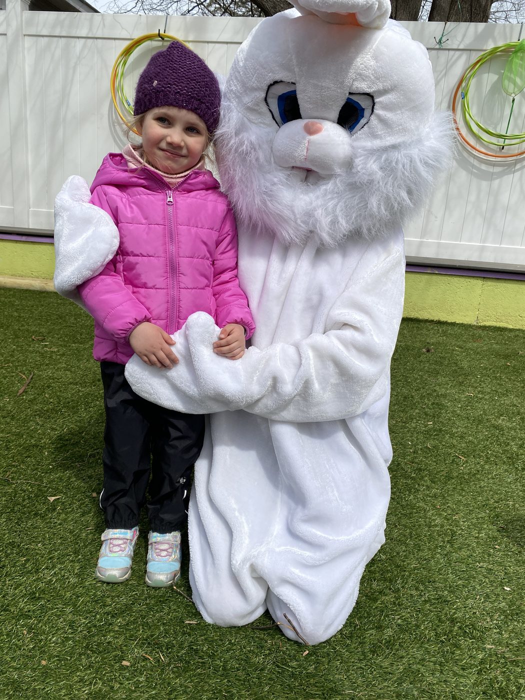 A child posing with the Easter bunny in the outdoor playground
