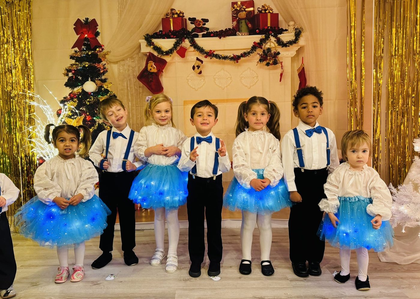 Children in matching festive outfits posing for a holiday show